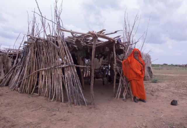 امرأة سودانية أمام كوخ في إحدى الولايات